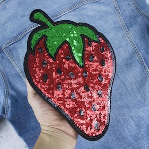May include: A red and green sequined strawberry patch, perfect for adding a touch of whimsy to denim jackets, bags, or other fabric items.