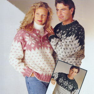 May include: A couple wearing matching knitted sweaters. The woman's sweater is pink and white with a snowflake design, while the man's is green and gray. A framed image shows the man in the same sweater.