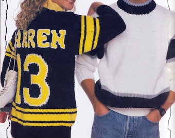 Op de afbeelding: Een zwart en geel gebreid hockey-shirt met de naam "AREN" en het nummer "13" op de rug. Het shirt heeft gele strepen op de mouwen en onderkant. Een witte en grijze trui is ook zichtbaar.