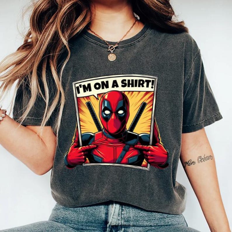 May include: A black t-shirt featuring a comic book style graphic of Deadpool pointing at himself and saying "I'm on a shirt!"
