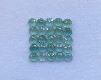 May include: A collection of twenty-eight round, faceted gemstones in varying shades of teal and aqua. The gems are arranged in a grid pattern against a white background, showcasing their clarity and cut. Each gem appears to be approximately 0.25 inches in diameter.