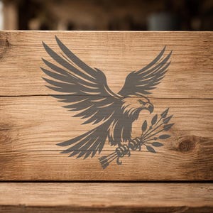 May include: A wooden sign with a detailed gray eagle design. The eagle is depicted with outstretched wings, holding a bundle of arrows and leaves. The sign has a natural wood grain background.