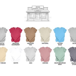 May include: A selection of short-sleeved t-shirts in various colors, including Athletic Heather, Heather Raspberry, and Ocean Blue. The image also features a line drawing of a general store at the top, with the text "PINE GENERAL STORE".