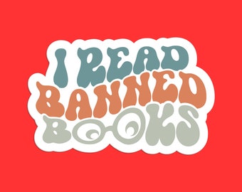 May include: A sticker with the text "I Read Banned Books" in a retro, psychedelic font style. The words are in shades of blue, orange, and gray.