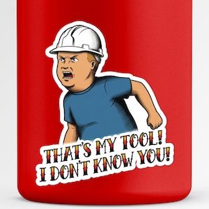 Op de afbeelding: Rode beker met een cartoonafbeelding van een jongen met een witte helm en een blauw shirt, met de tekst "THAT'S MY TOOL! I DON'T KNOW YOU!" in een gestileerd lettertype. Het ontwerp is een humoristische verwijzing.