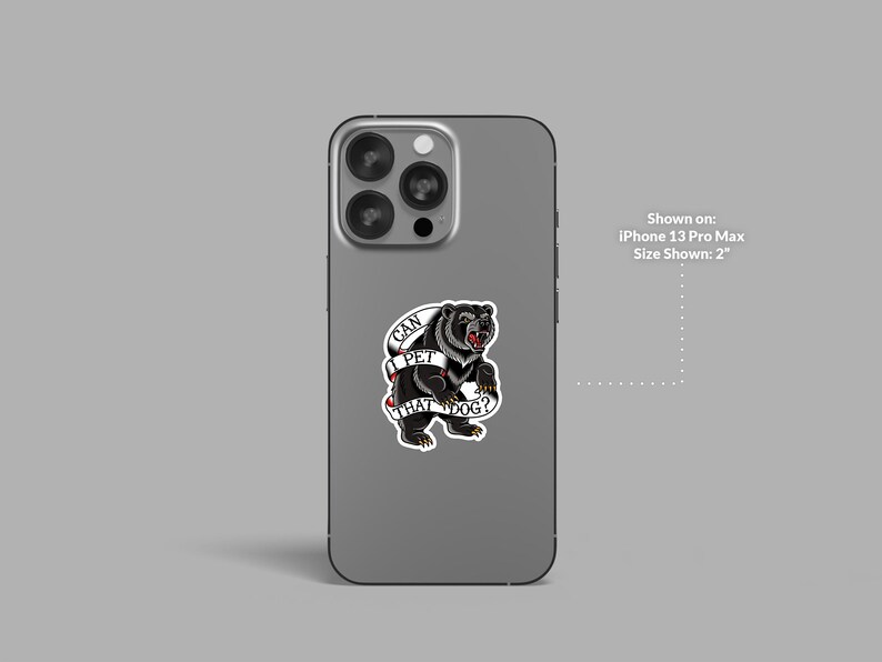 May include: A sticker featuring a black bear with a red tongue and the text "CAN I PET THAT DOG?" on a banner. The sticker is shown on an iPhone 13 Pro Max, with a size of 2 inches.
