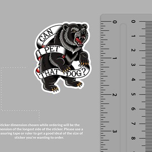 May include: A sticker featuring a black bear with an open mouth and red tongue. The bear is standing on its hind legs. A banner across the bear reads "CAN I PET THAT DOG?" in a classic tattoo style.