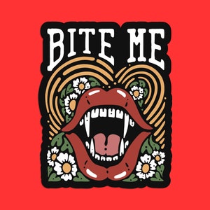 May include: A black and white sticker with the text "Bite Me" in a bold white font. The sticker features a red, open mouth with fangs and a tongue sticking out. The mouth is surrounded by a yellow and brown swirl pattern with white flowers.