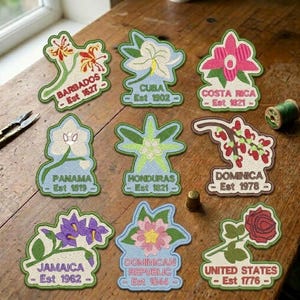 May include: Nine embroidered patches featuring various national flowers and country names with establishment dates: Barbados Est 1627, Cuba Est 1902, Costa Rica Est 1821, Panama Est 1519, Honduras Est 1821, Dominica Est 1978, Jamaica Est 1962, Dominican Republic Est 1844, and United States Est 1776.