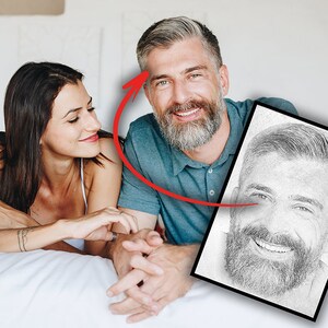 May include: A black and white pencil sketch of a man with a beard and a smile. The sketch is framed in a black frame.