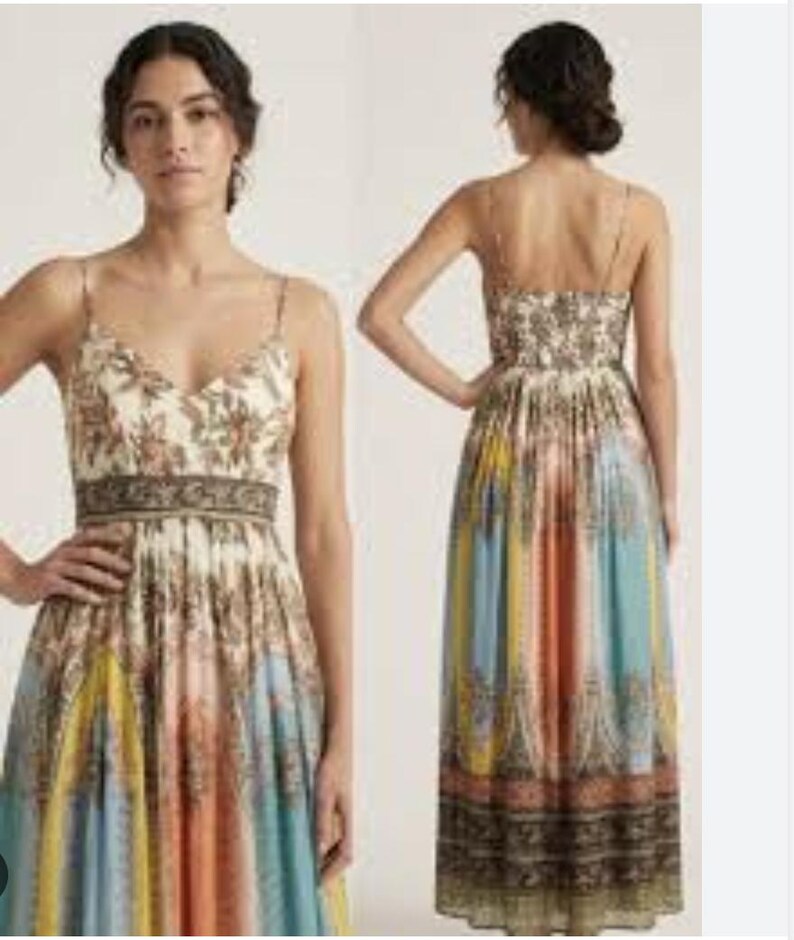 May include: A long, flowing dress with a floral bodice and a patterned skirt. The dress features thin straps, a V-neckline, and a fitted waist. The skirt showcases vertical stripes in shades of blue, yellow, and orange, with a detailed border.