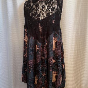 May include: A sleeveless black and pink floral dress with a black lace overlay on the back.