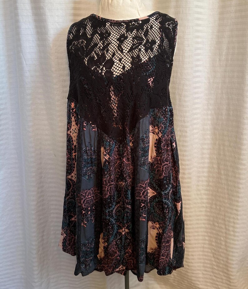 May include: A sleeveless black and pink floral dress with a black lace overlay on the back.