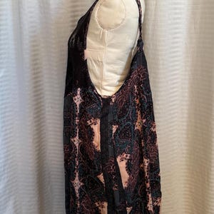May include: A black and pink sleeveless dress with a paisley pattern. The dress has a lace trim on the neckline and straps.