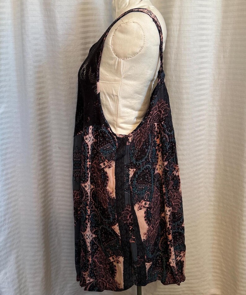 May include: A black and pink sleeveless dress with a paisley pattern. The dress has a lace trim on the neckline and straps.