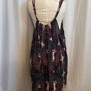 May include: A sleeveless, black and pink floral print dress with a scoop neck and a low back.