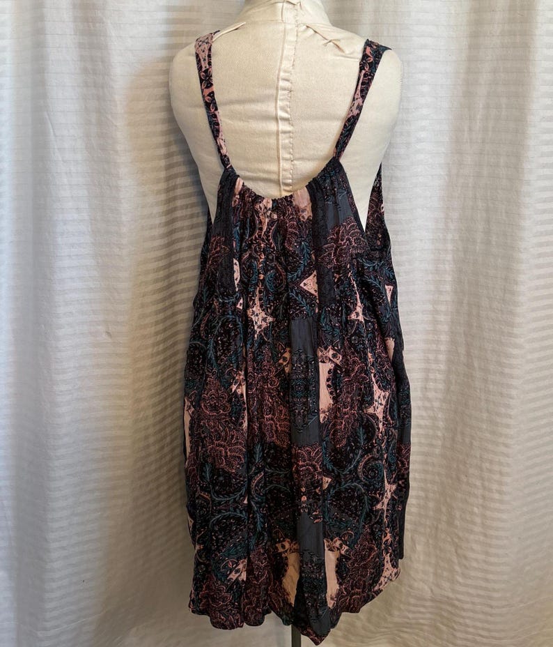 May include: A sleeveless, black and pink floral print dress with a scoop neck and a low back.