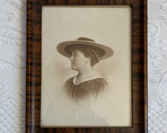 framed sepia photo . portrait photo of a lady . around 1920 . painted wood frame . sepia photo