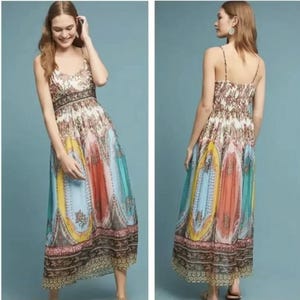 May include: A long, patterned dress with spaghetti straps. The dress features a mix of colors including blue, yellow, orange, and pink. The bodice has a floral pattern, and the skirt has a paisley design. The dress is floor-length.