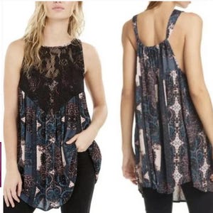 May include: A sleeveless, loose-fitting, black and blue patterned top with a black lace overlay. The top has a high neckline and a slightly longer back hem.