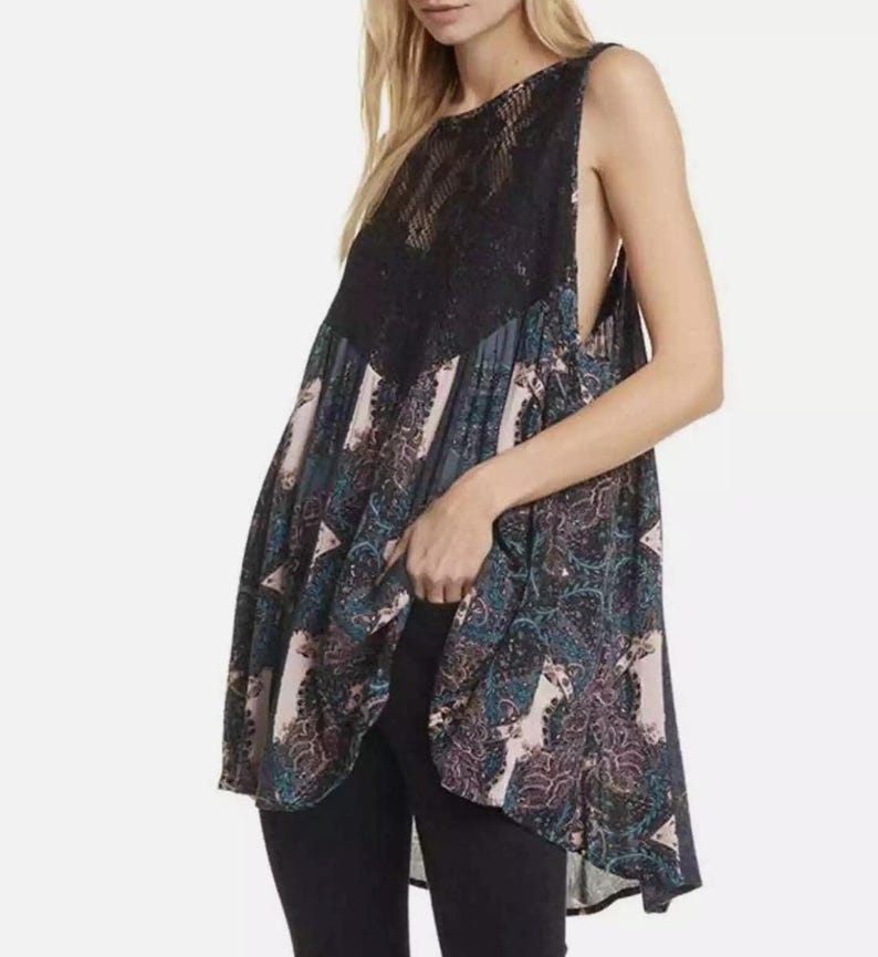 May include: A sleeveless, black and blue paisley print tunic with a black lace overlay at the neckline. The tunic has a high neckline and a loose, flowing fit.