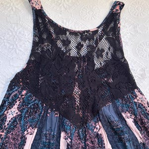 May include: A sleeveless dress with a black lace overlay and a floral print in shades of pink, blue, and gray.