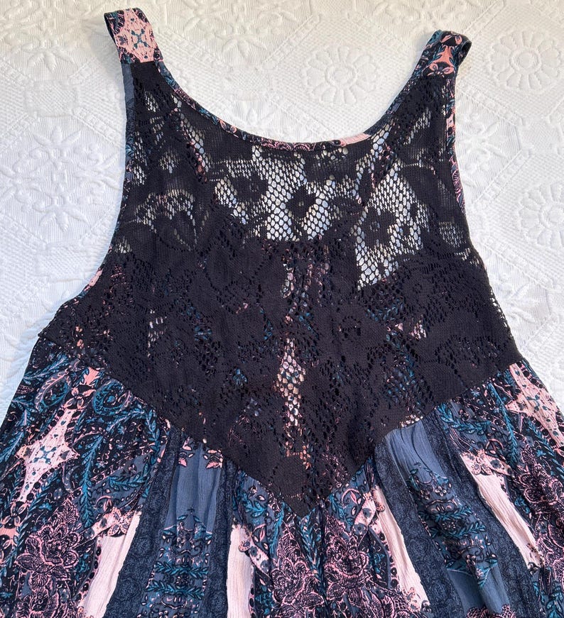 May include: A sleeveless dress with a black lace overlay and a floral print in shades of pink, blue, and gray.