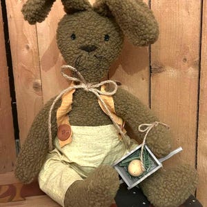 春のうさぎ - かわいいふっくらとしたうさぎ、木製のカート、まだら模様の卵。イースターのホームデコレーション。うさぎ