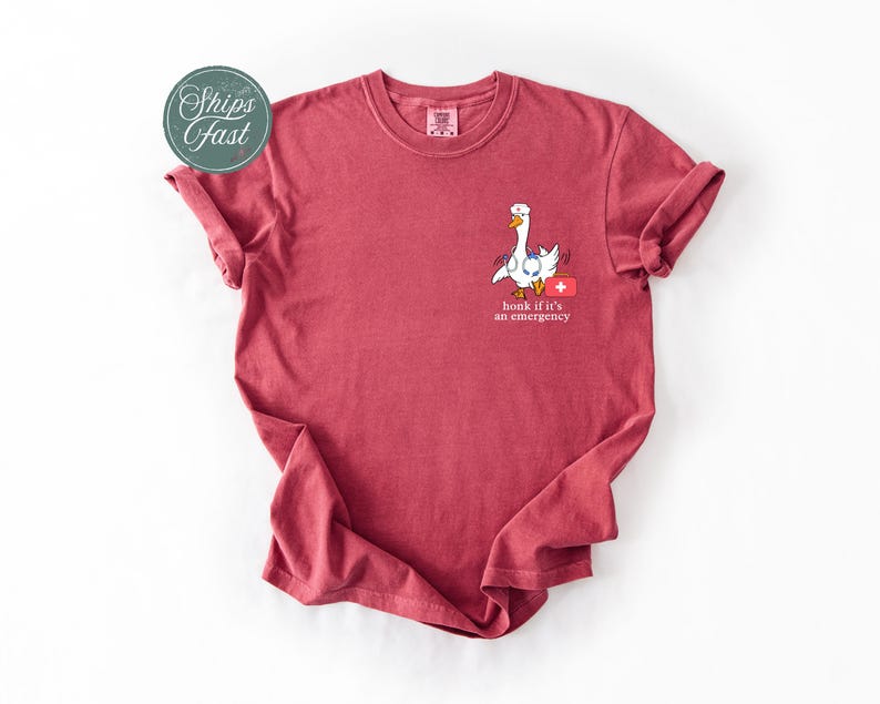 May include: A red t-shirt featuring a white goose graphic and the text "honk if it's an emergency".