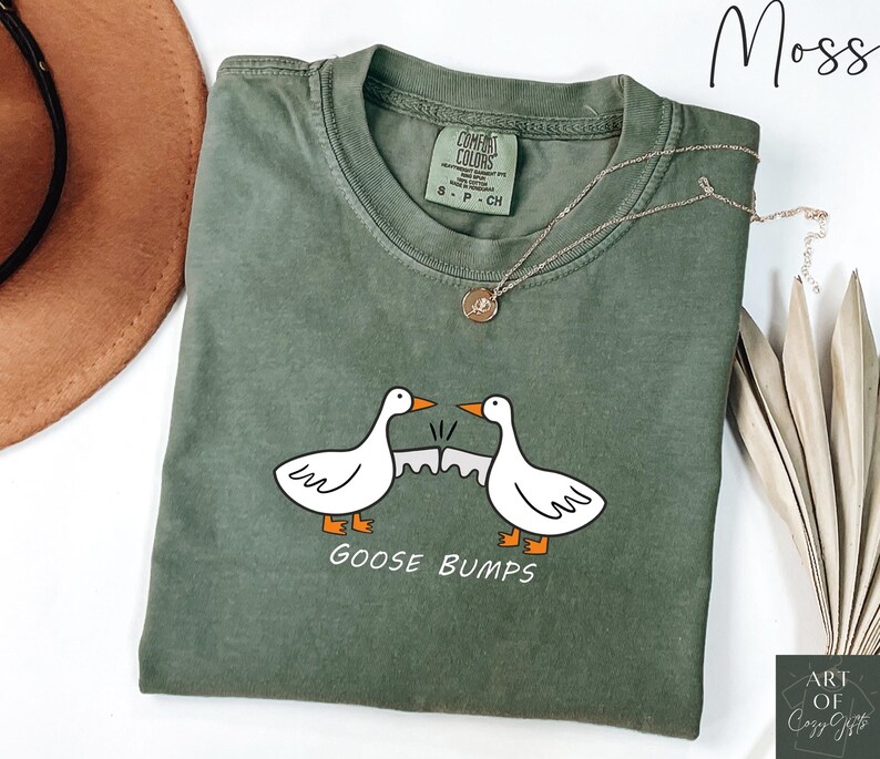 May include: A green t-shirt with a white goose design and the text "GOOSE BUMPS".