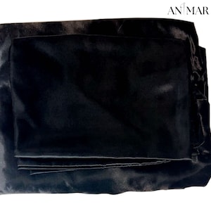 May include: A black satin pillowcase set, folded and ready for use. The pillowcases are made of a soft, luxurious fabric and are perfect for adding a touch of elegance to any bedroom.
