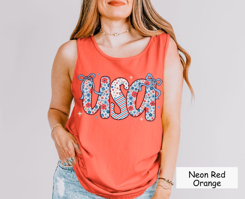Neon red-orange Comfort Colors tank top with floral USA graphic. A trendy patriotic tank for women, ideal for Independence Day, backyard BBQs, and summer events. This 4th of July shirt makes the perfect red white and blue outfit idea
