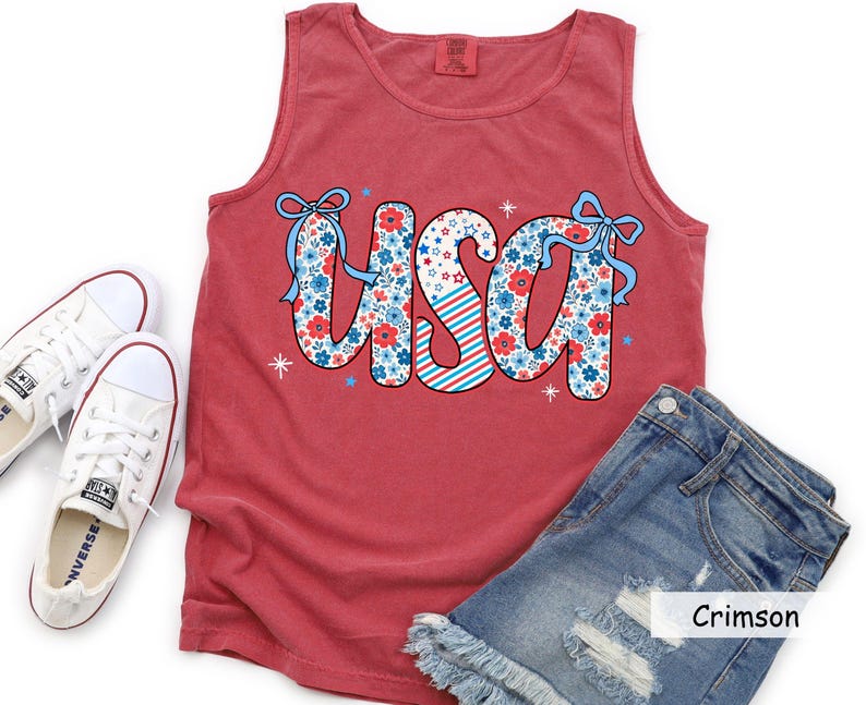 Flatlay of red crimson Comfort Colors USA tank styled with Converse and distressed shorts. Perfect for women’s 4th of July outfit ideas, patriotic BBQ shirts, or festive Americana summer fashion.