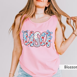 Pink Comfort Colors USA tank with red white and blue floral print. Perfect 4th of July shirt for women, styled for summer parties, patriotic events, and casual Americana outfits. Great for a cute and festive July Fourth tank look.