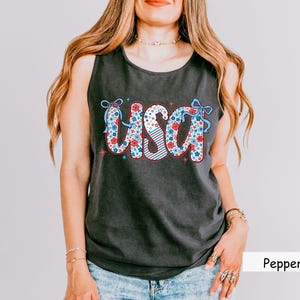 Dark grey “Pepper” Comfort Colors tank with floral patriotic USA print. Ideal 4th of July shirt for women looking for a vintage-inspired red white and blue tank. Pairs great with jean shorts for holiday cookouts.
