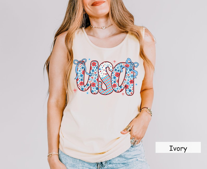 Ivory USA tank top for women with floral patriotic graphic. This neutral-toned 4th of July shirt is perfect for summer picnics, Independence Day outfits, and casual red white and blue looks in soft Comfort Colors fabric.