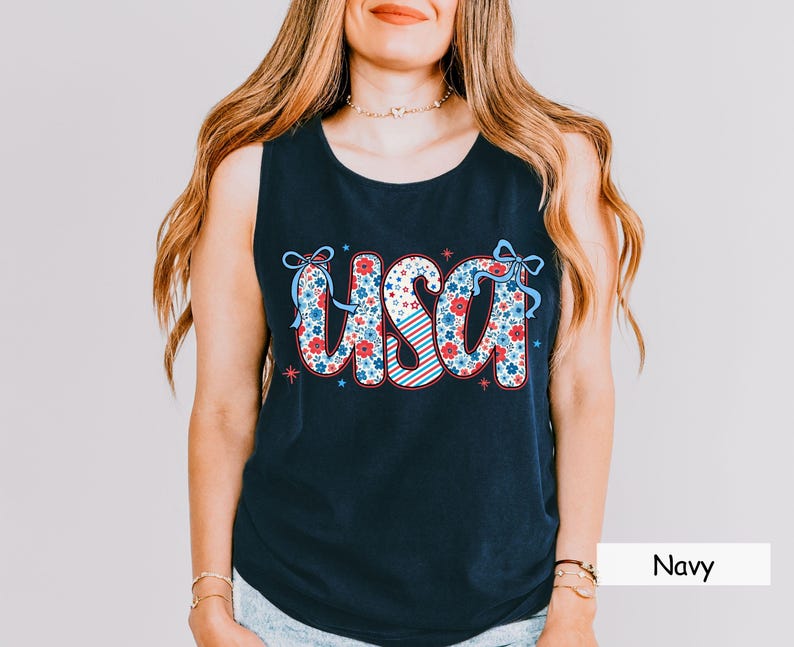 Navy Comfort Colors tank with floral USA design in red, white, and blue. A classic patriotic tank for women perfect for 4th of July parades, summer lake days, or America-themed outfits. Styled with casual denim.