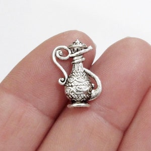 May include: Silver charm in the shape of a detailed ornate pitcher with a curved spout.