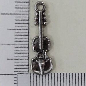 May include: Silver-toned metal charm shaped like a violin. The charm has a loop at the top for attaching to a necklace or bracelet.
