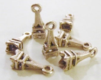 May include: Small, silver-colored Eiffel Tower charms. Each charm features the iconic tower design with intricate details and a loop at the top for attaching to jewelry or other crafts. The charms are approximately 0.75 inches tall.