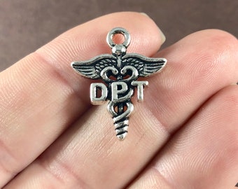 Puede incluir: Encanto de plata con un símbolo de caduceo médico y las letras "DPT" en él.