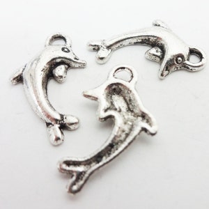 May include: Three silver dolphin charms with a loop for attaching to jewelry or other crafts.