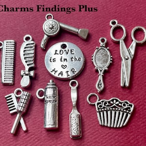 May include: A set of ten silver charm pendants with a hairdressing theme. The charms include a comb, scissors, hairspray, a hair dryer, a round mirror, a hairbrush, and a charm with the text "Love is in the hair".
