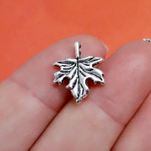 May include: Silver-toned metal maple leaf charm with a detailed design. The charm is perfect for jewelry making, scrapbooking, and other craft projects.