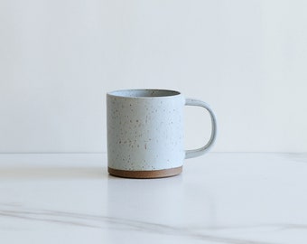 SECONDS SALE : 10 oz mug. Speckled clay, glazed in a pale blue.