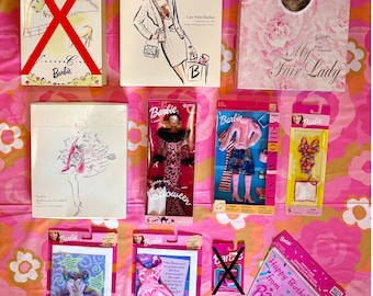 May include: A collection of vintage Barbie dolls and accessories, including boxed dolls, fashion sets, and a birthday banner. The boxes feature illustrations and the banner reads "Happy Birthday from Barbie."