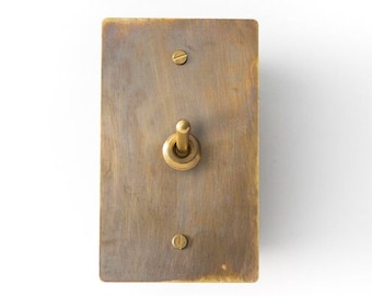 Light switch with antique brass plate