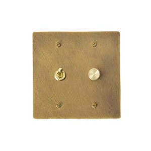 May include: A brass wall plate with two switches, one toggle switch and one round knob.