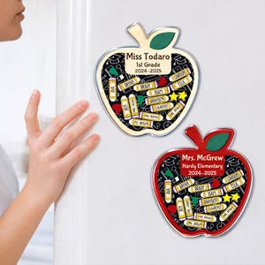 May include: Two apple-shaped magnets. One is red, the other is natural wood. Both have a black background with school-themed icons and student names. The wooden apple says "Miss Todaro 1st Grade 2024-2025". The red apple says "Mrs. McGrew Hardy Elementary 2024-2025".