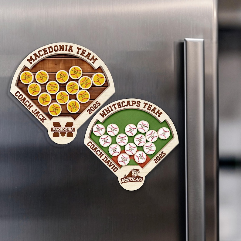 May include: Two wooden baseball-themed magnets. One magnet reads "Macedonia Team" with a brown wooden background and yellow baseballs. The other magnet reads "Whitecaps Team" with a green background and white baseballs. Both magnets have the year 2025.